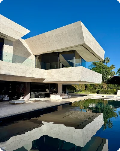 A villa with cantilevered stone floors reflected in a dark pool
